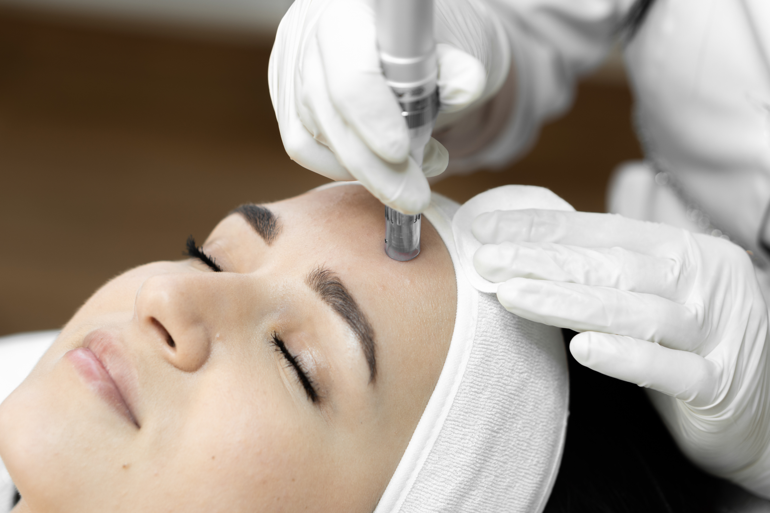 The photo conveys the moment of fractional mesotherapy, emphasizing the professionalism and experience cosmetologist in beauty clinic. Beautiful close-up girl at reception at doctor cosmetologist